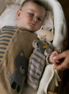 Gugú Mayoral hängt gestreiften Schnuller für Babys auf.